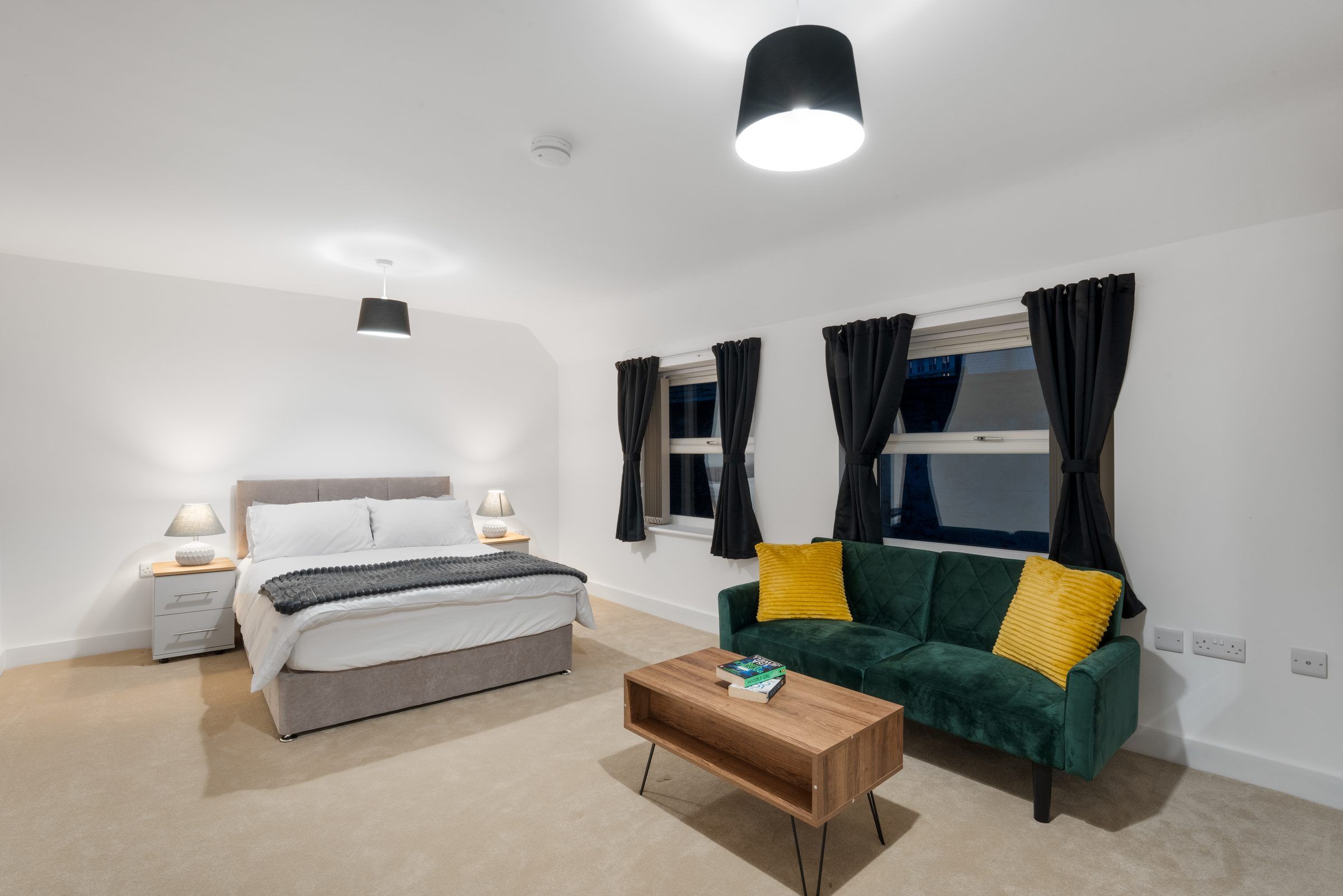 Bedroom with green velvet sofa and coffee table