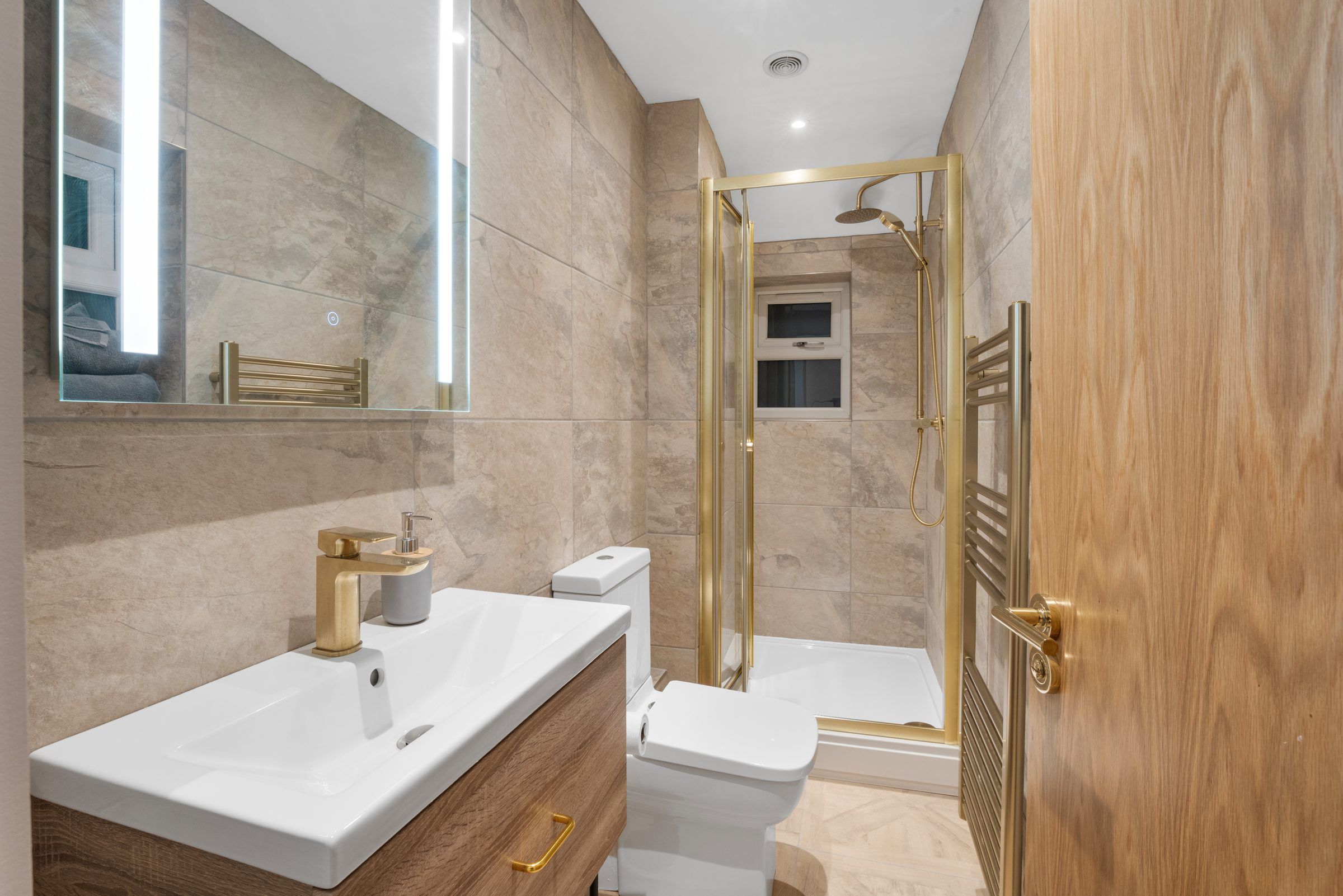 Bathroom with marble-effect tiles and brass fittings