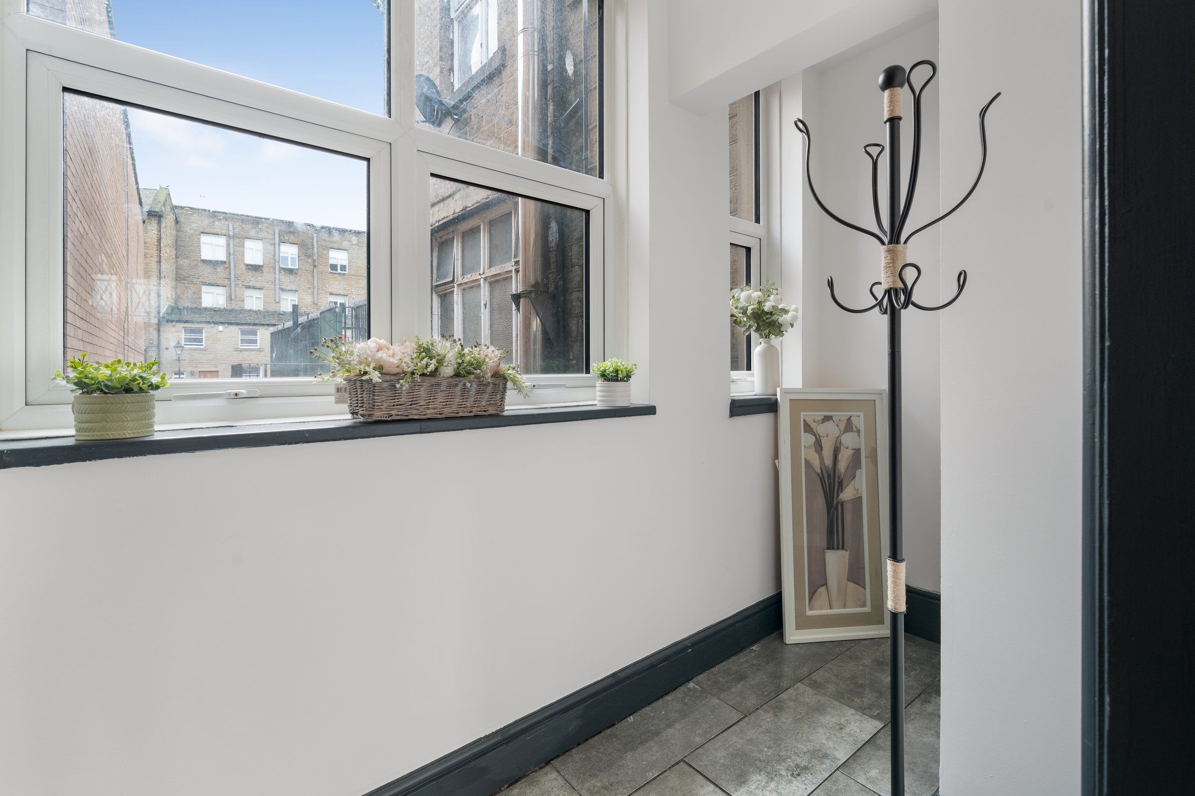 Bright window seat with plants and a view over stone buildings
