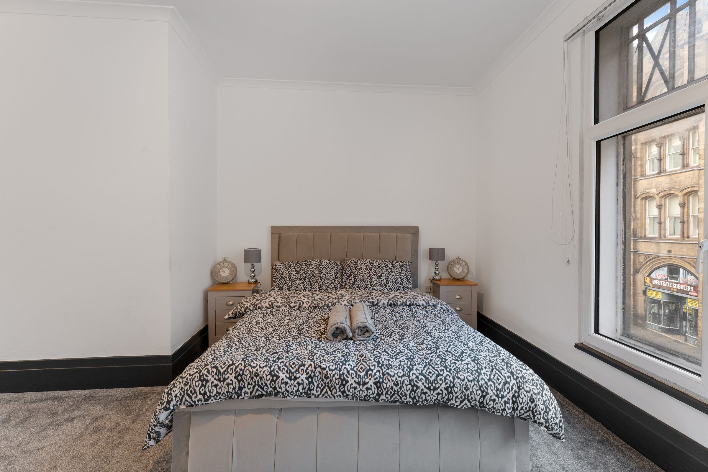 Bedroom with patterned bedding and tall windows