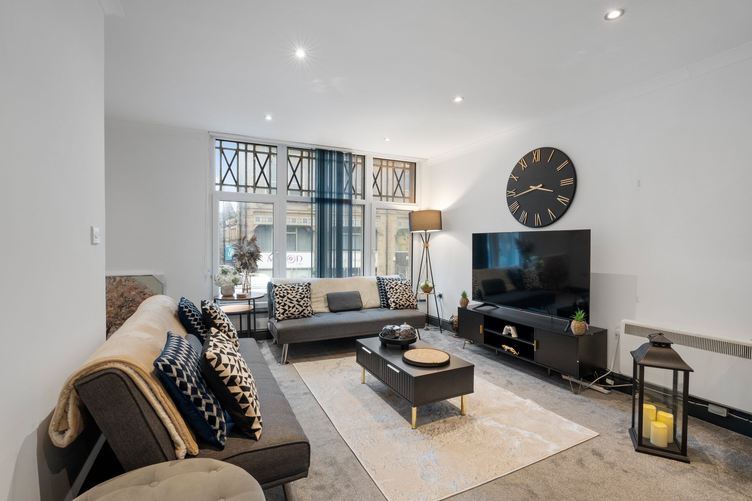 Living room with sofa, rug and large wall clock