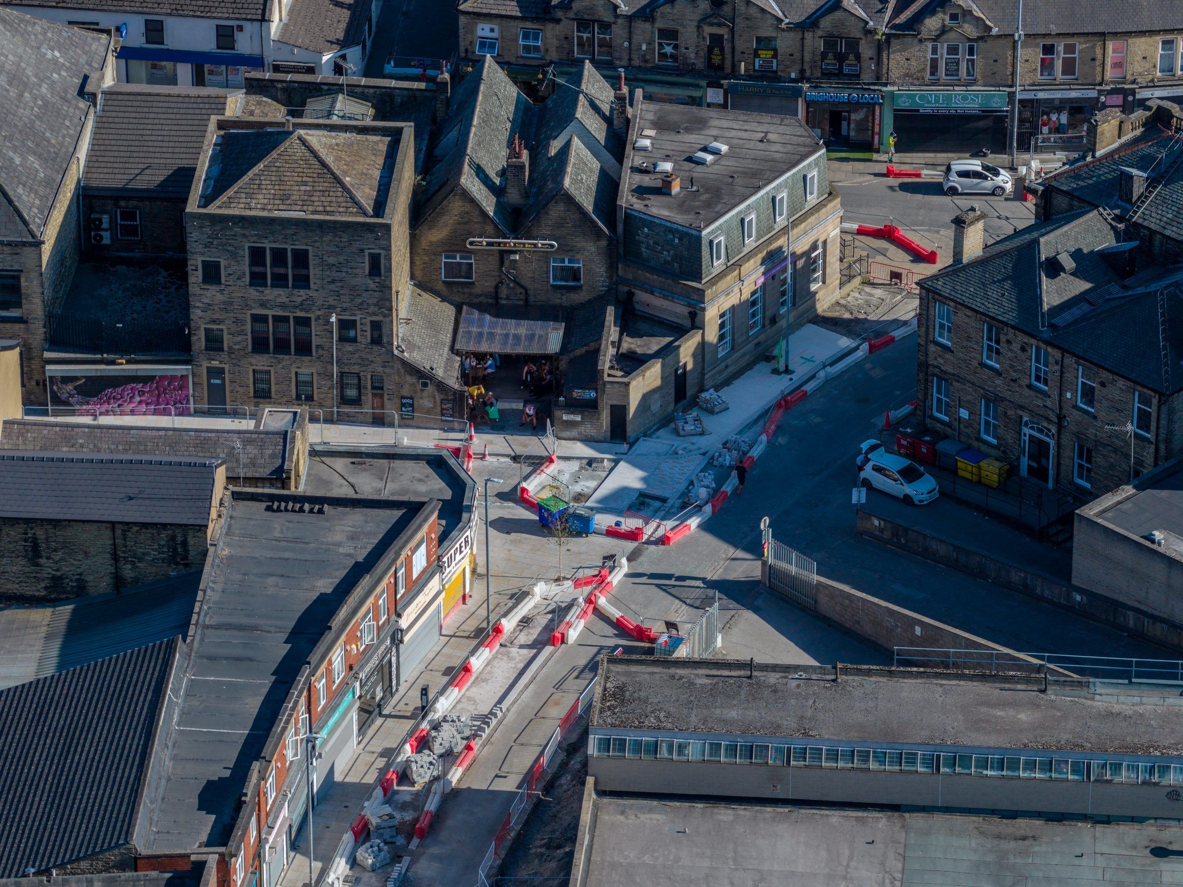 Angled aerial of a junction with barriers and stone buildings