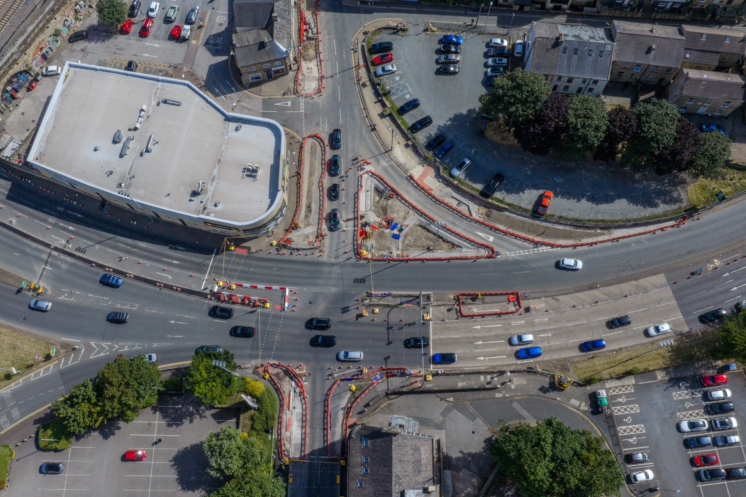 Top-down aerial of a busy road junction and car parks